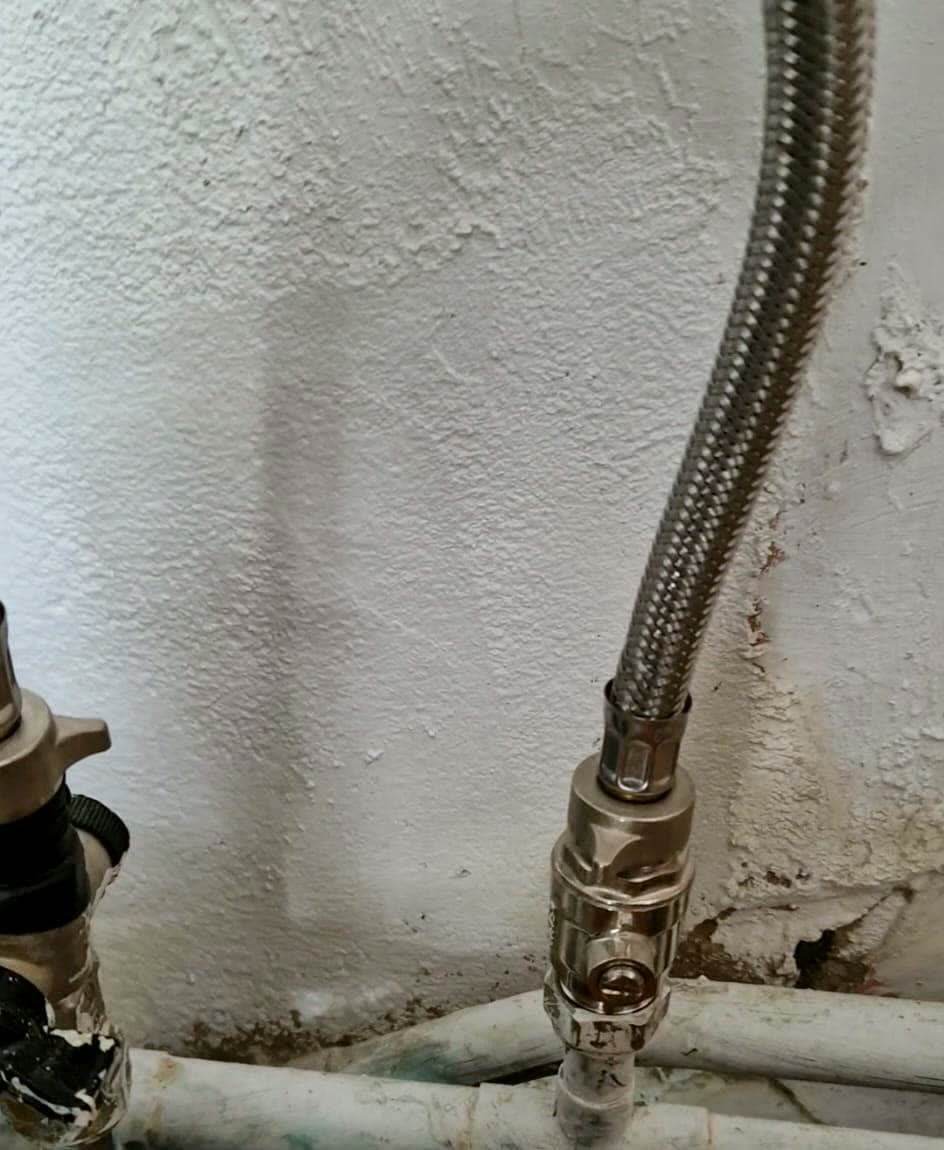 Isolation valve and braided flexible hose connected to pipework